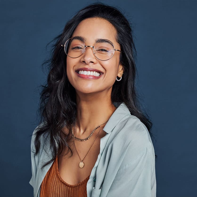 a woman wearing glasses and smiling at the camera
